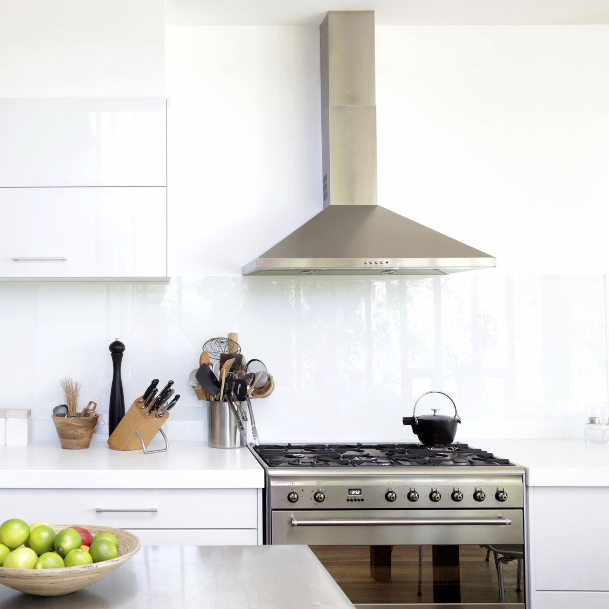 Stainless gas range and hood in a bright kitchen
